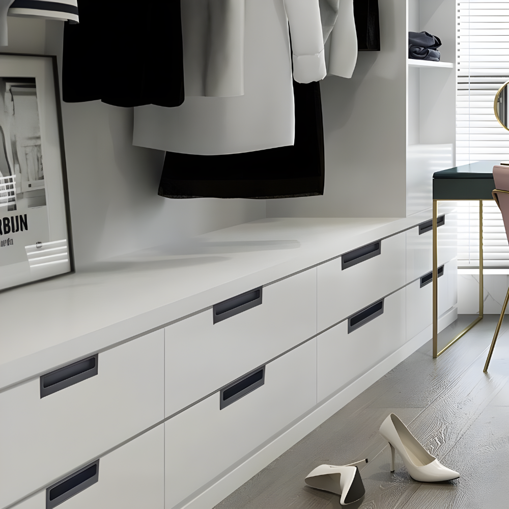 A modern wardrobe with black doors featuring minimalistic embedded handles, part of a furniture set possibly in a residential interior.