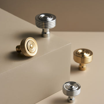 EPIDAVROS ribbed knobs in Chrome and Polished Gold on a stone plinth