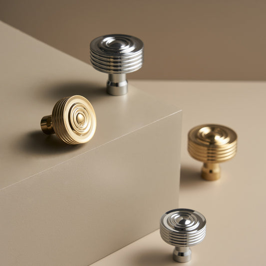 EPIDAVROS ribbed knobs in Chrome and Polished Gold on a stone plinth