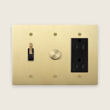 Custom KLAS switch plate in satin brass with toggle, rotary dimmer and outlet
