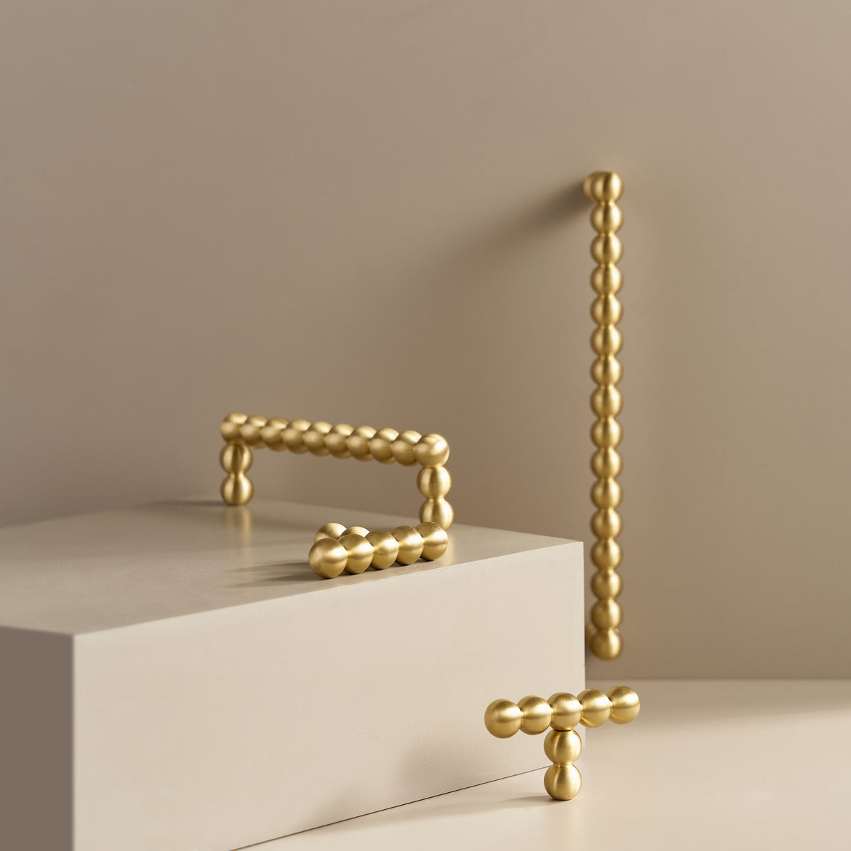 KOMBOLOI beaded brass handles and T-pull on a stone plinth