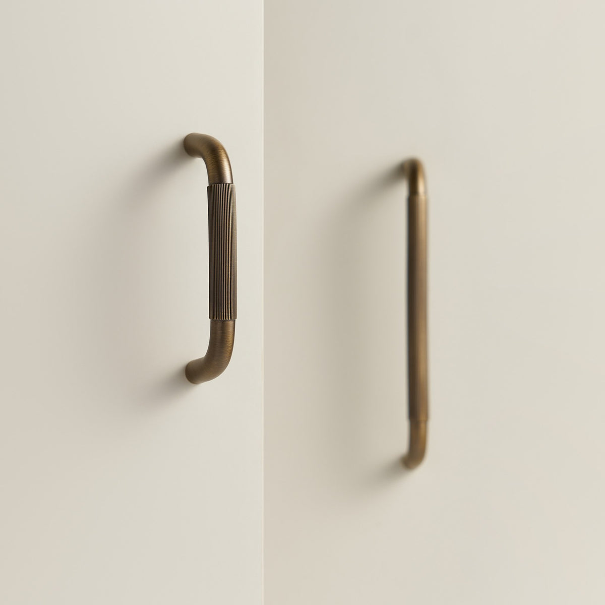 NEMEA reeded brass handles in Antique Brass on cream cabinet doors
