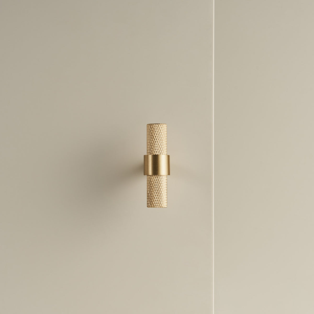 OPORTO knurled T-pull in Satin Brass on a cabinet door
