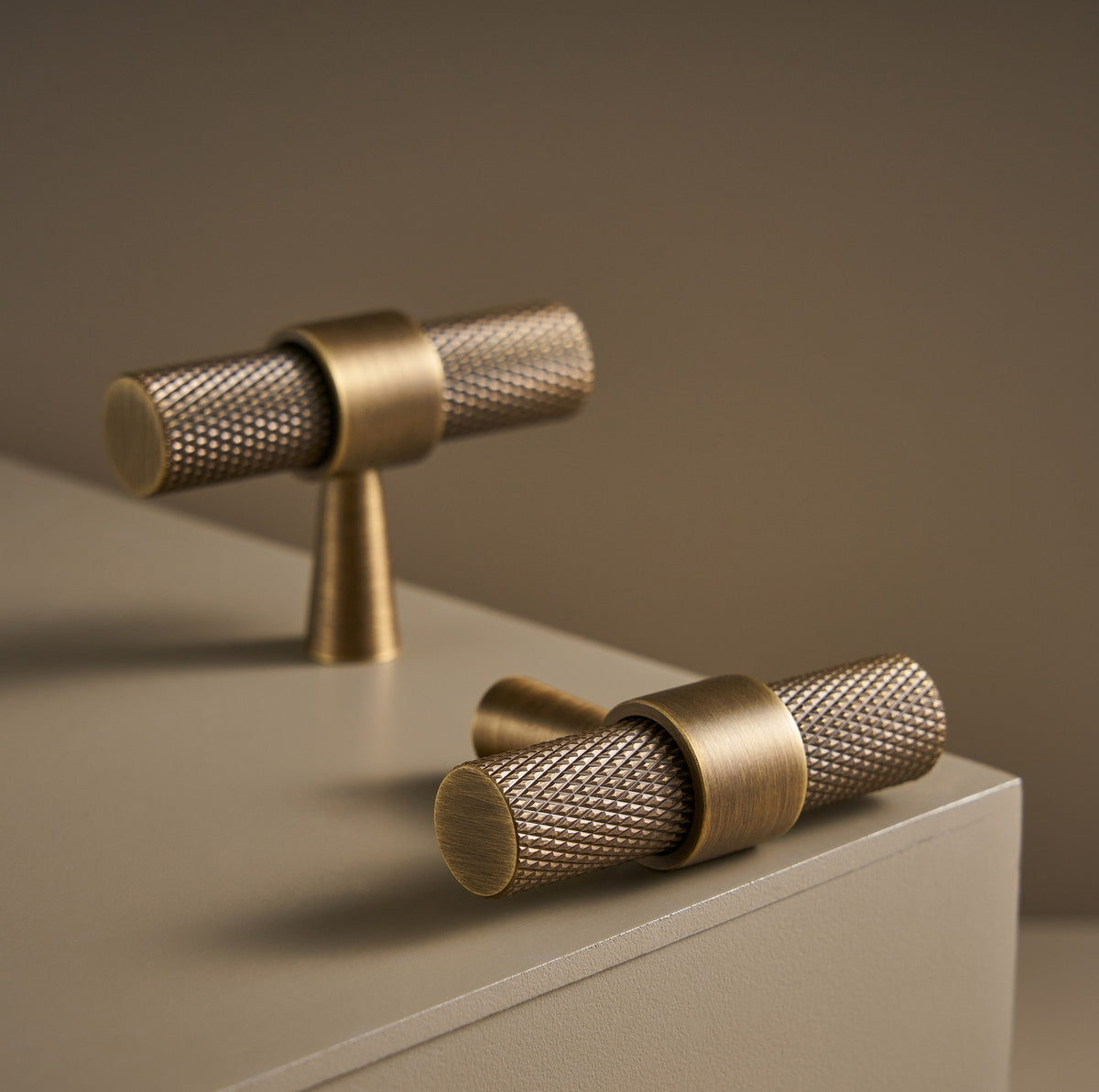 OPORTO knurled T-pulls in Antique Brass on a ledge