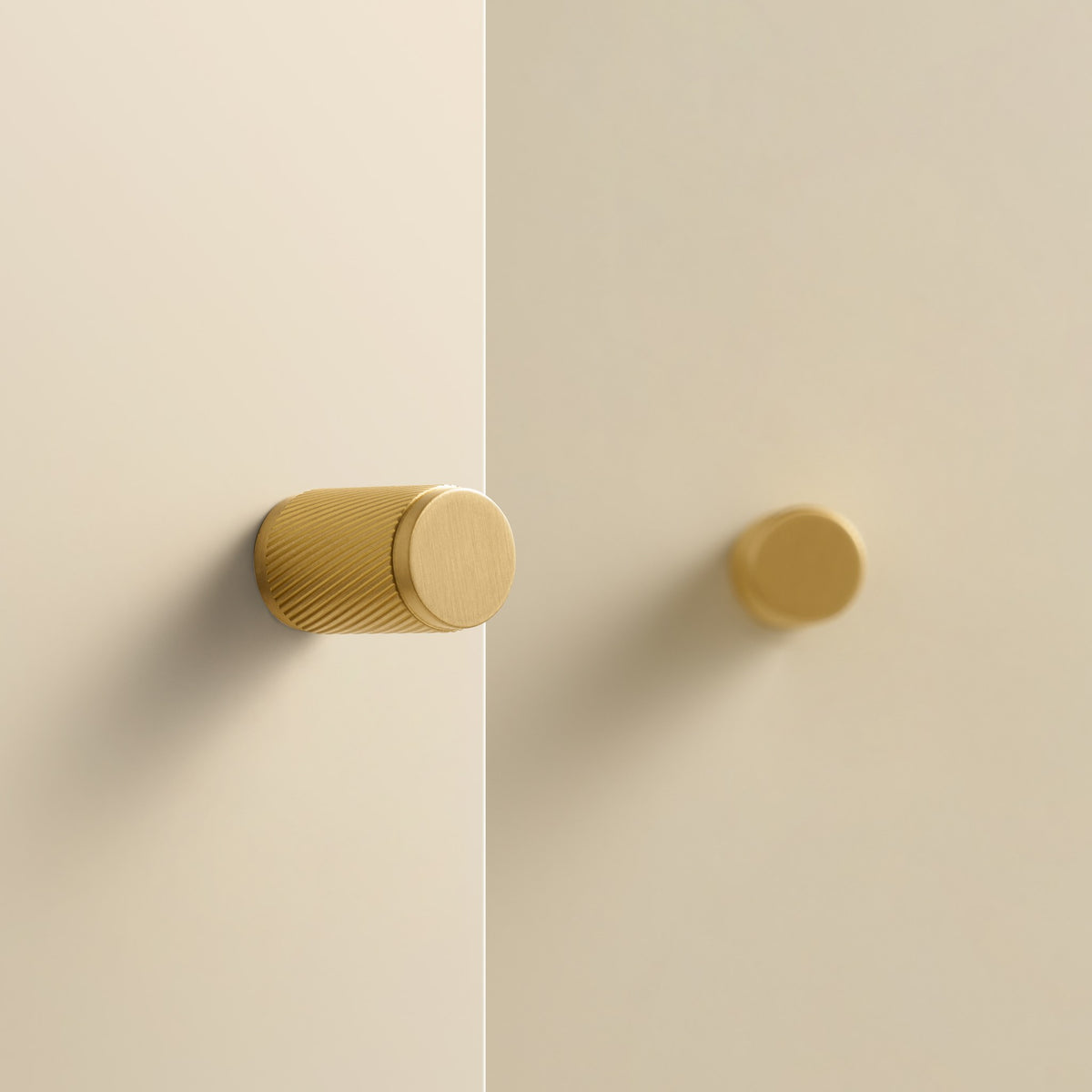 PALENCIA swirled knurl brass knobs in Satin Brass on cream cabinet doors
