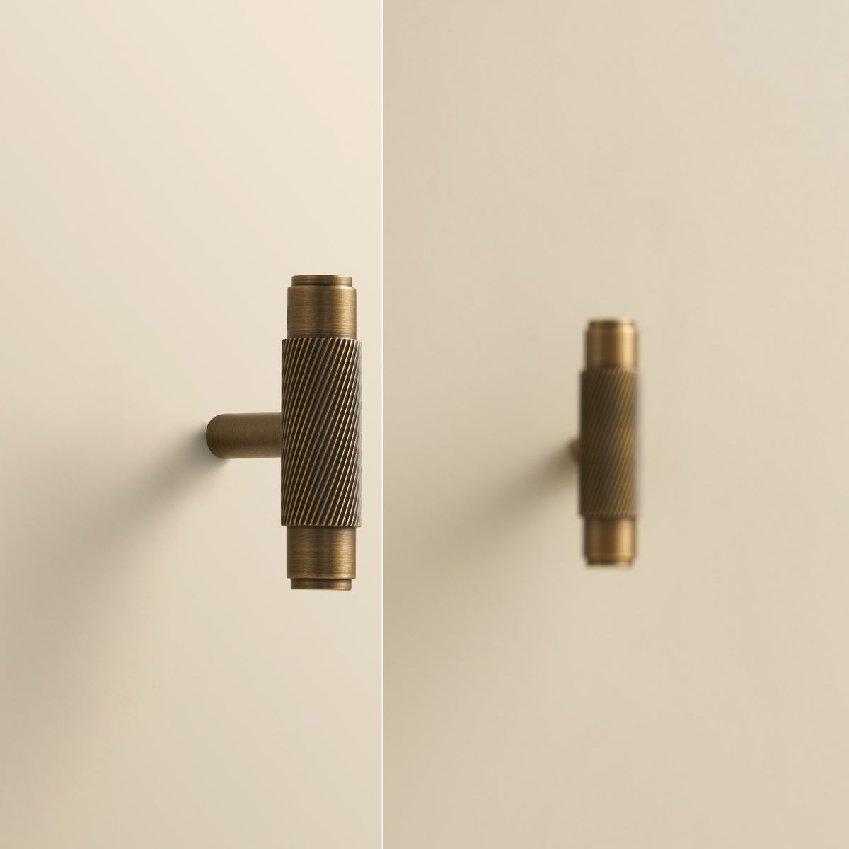 PALENCIA swirled knurl brass T-pulls in Antique Brass on cabinet doors
